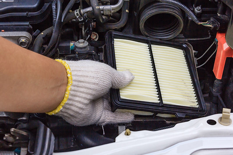 GM mechanic replacing an air filter.