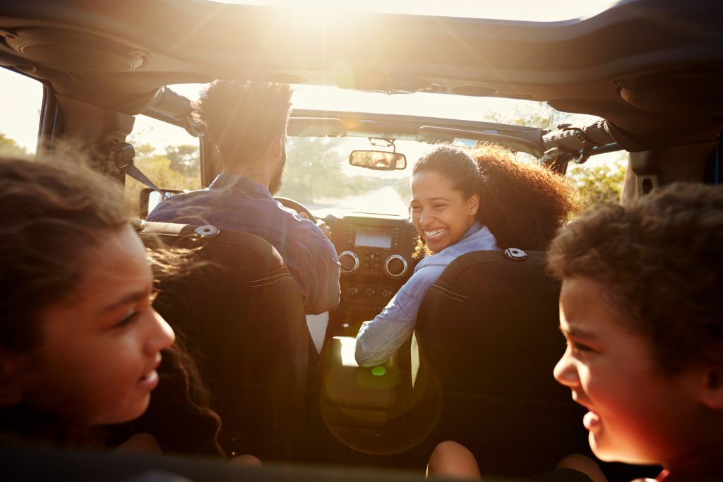 A happy family on a road trip in their SUV.