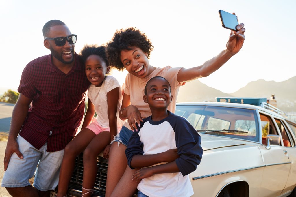 A happy family taking a selfie together during a road trip.